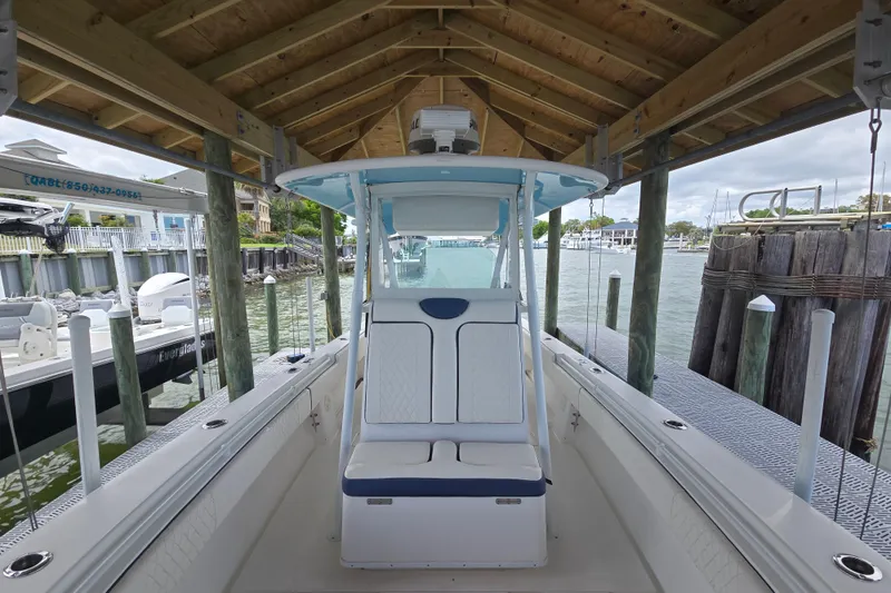 Slide: The Image of 2012 Contender 32 LS boat docked under a wooden shelter by the water. - 8