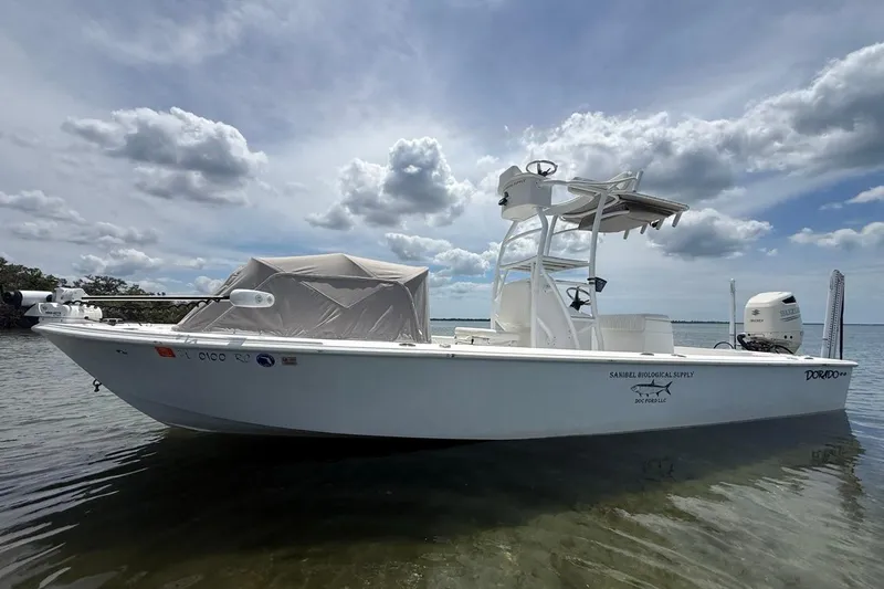 The Image of 2016 Dorado 25 SE boat on calm water under cloudy sky. - 0