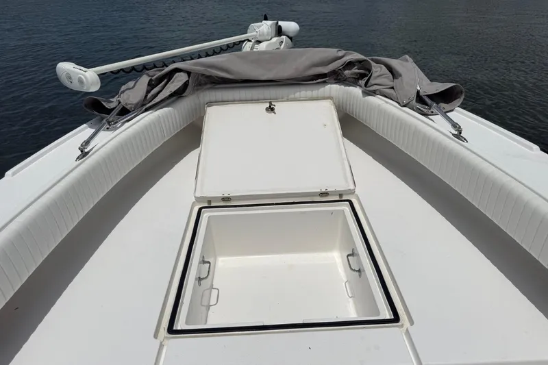 Slide: The Image of 2016 Dorado 25 SE boat deck with open storage compartment, on calm water. - 22