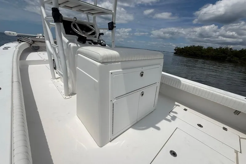 Slide: The Image of 2016 Dorado 25 SE boat interior with steering console, white seating, and storage compartments. - 24