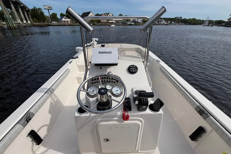 Slide: The Image of 2025 Carolina Skiff 21LS boat console with steering wheel and navigation equipment on water. - 12