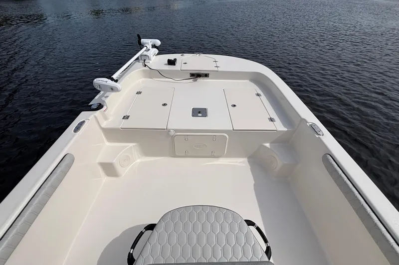 Slide: The Image of 2025 Carolina Skiff 21LS boat interior with storage compartments on calm water. - 13