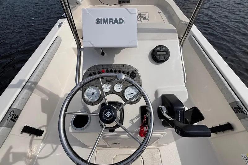 Slide: The Image of 2025 Carolina Skiff 21LS boat dashboard with Simrad display and steering wheel. - 14