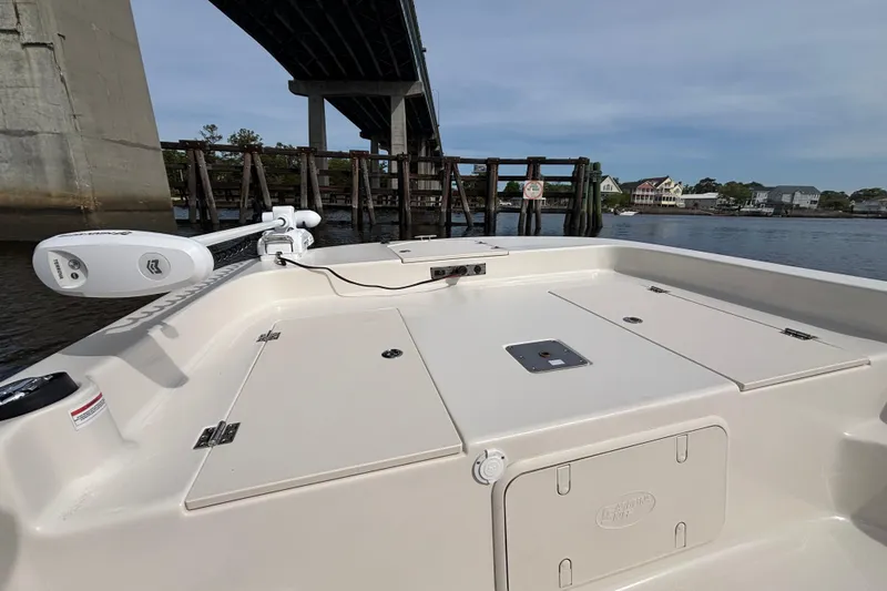 Slide: The Image of 2025 Carolina Skiff 21LS boat under bridge, featuring spacious deck and modern design. - 7