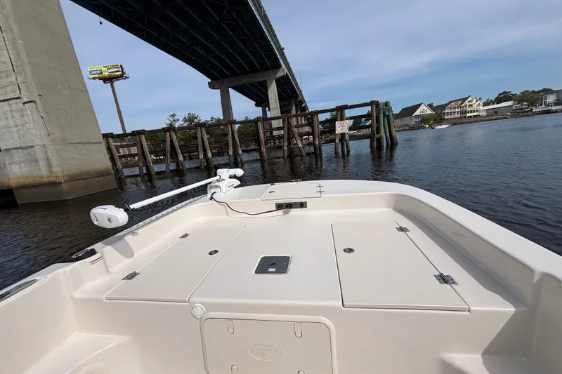 Slide: The Image of 2025 Carolina Skiff 21LS boat under bridge on calm waterway. - 8