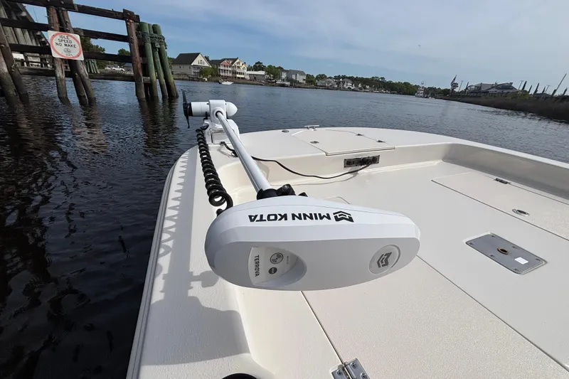 Slide: The Image of 2025 Carolina Skiff 21LS boat with Minn Kota trolling motor on calm water. - 9