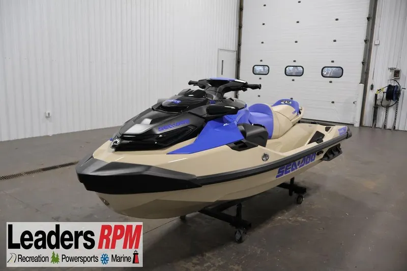 The Image of 2025 Sea-Doo Wake Pro 230 jet ski in showroom, featuring blue and beige design. - 2