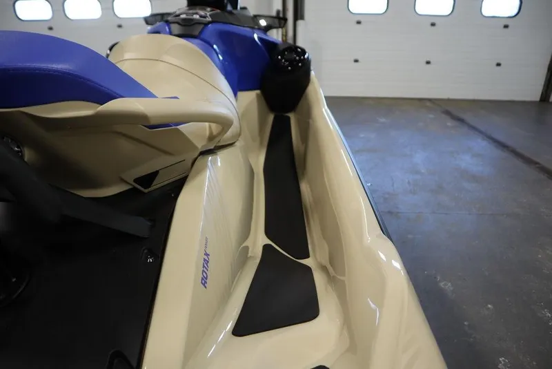 Slide: The Image of 2025 Sea-Doo Wake Pro 230 jet ski, beige and blue, in a garage setting. - 23