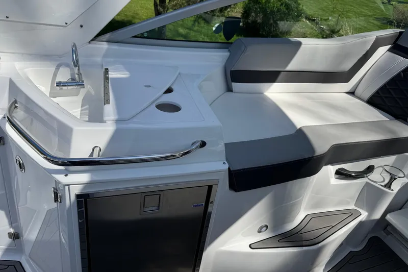 Slide: The Image of 2021 Monterey 295 Sport Yacht interior with sink, seating, and storage. - 13