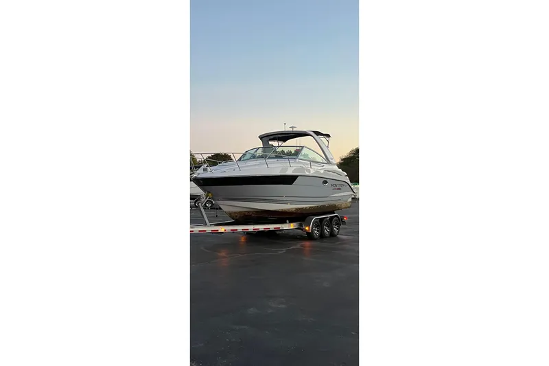 Slide: The Image of 2021 Monterey 295 Sport Yacht on trailer at sunset. - 2