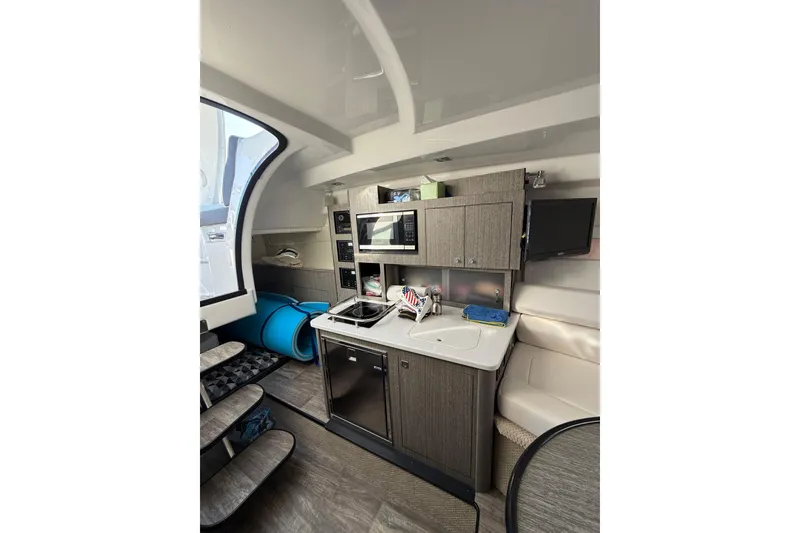 Slide: The Image of Interior of 2021 Monterey 295 Sport Yacht with kitchenette and seating area. - 21