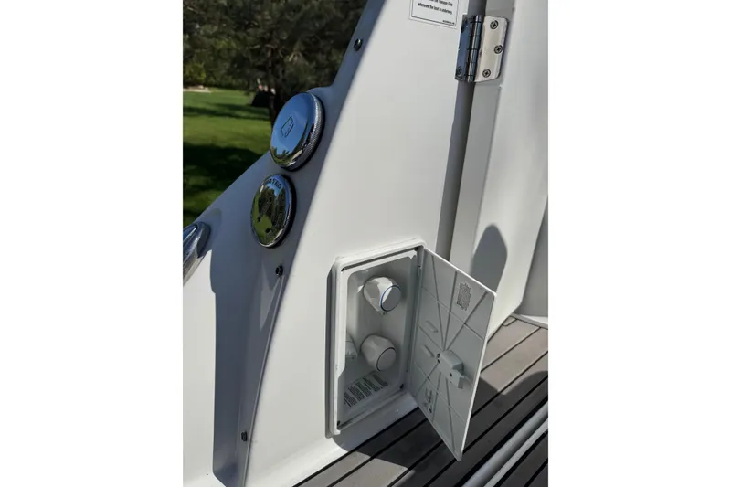 Slide: The Image of Control panel on 2021 Monterey 295 Sport Yacht, featuring chrome dials and open access panel. - 24