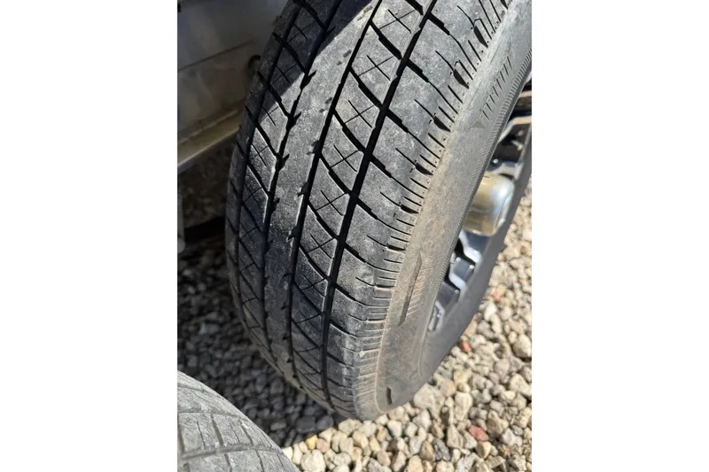 Slide: The Image of Close-up of a worn tire on gravel, related to a 2021 Monterey 295 Sport Yacht. - 27