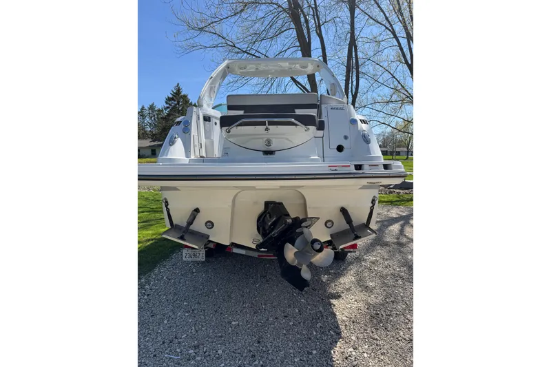 Slide: The Image of 2021 Monterey 295 Sport Yacht rear view with propeller, parked on gravel. - 6