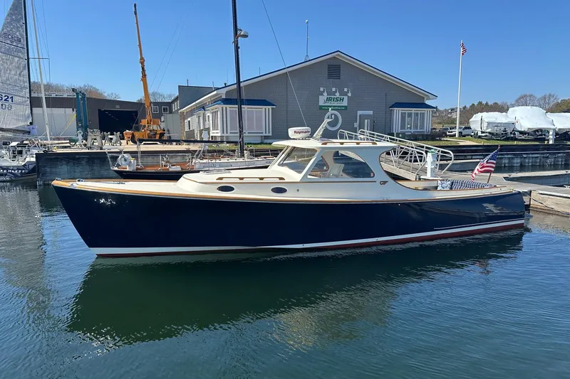 The Image of 1996 Hinckley Picnic Boat 36 Classic docked at a marina, featuring sleek design and American flag. - 0