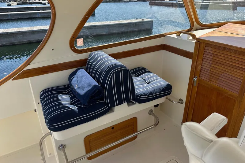 Slide: The Image of Interior of 1996 Hinckley Picnic Boat 36 Classic with striped seating and wooden accents. - 11