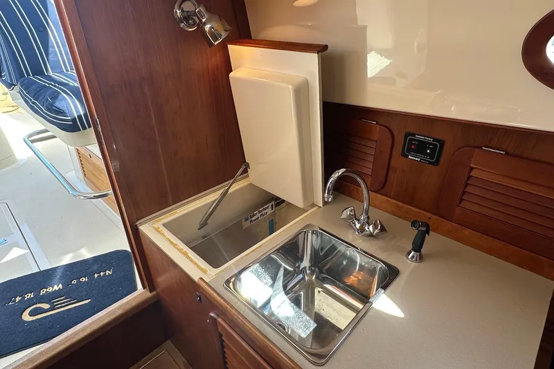 Slide: The Image of Hinckley Picnic Boat 36 Classic 1996 interior with sink and wooden cabinetry. - 13