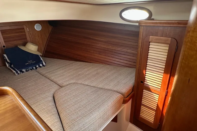 Slide: The Image of Cozy cabin interior of 1996 Hinckley Picnic Boat 36 Classic with wooden paneling and bedding. - 18