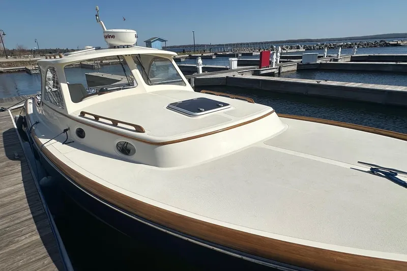 Slide: The Image of 1996 Hinckley Picnic Boat 36 Classic docked at a marina, showcasing elegant design. - 21