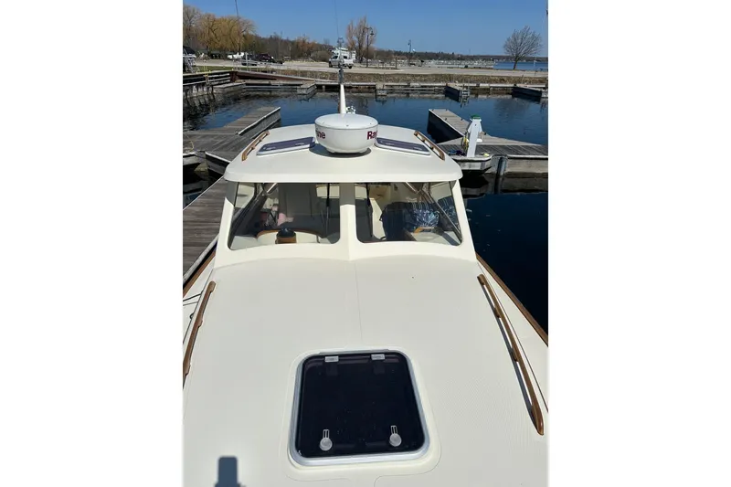 Slide: The Image of 1996 Hinckley Picnic Boat 36 Classic docked at a marina, viewed from the bow. - 23