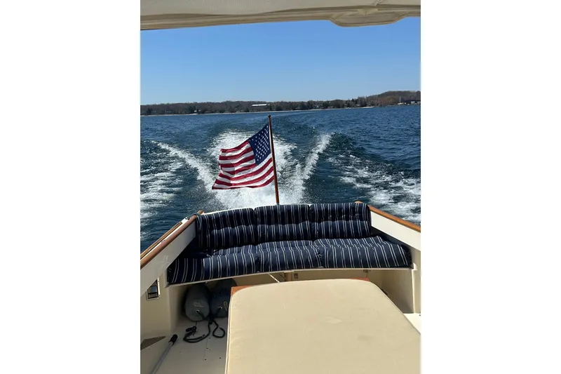 Slide: The Image of Hinckley Picnic Boat 36 Classic cruising with American flag, 1996 model. - 34