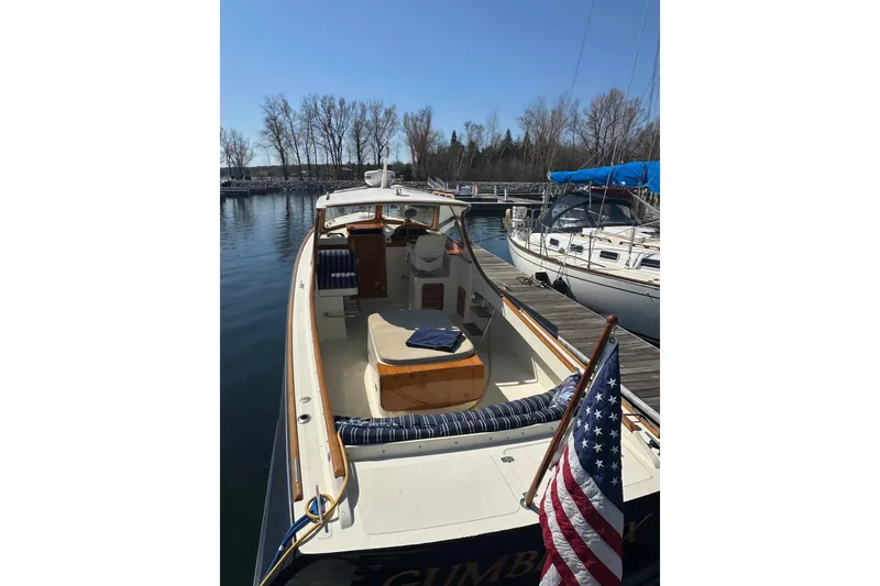 Slide: The Image of 1996 Hinckley Picnic Boat 36 Classic docked at marina with American flag. - 4