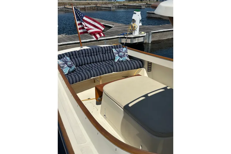 Slide: The Image of 1996 Hinckley Picnic Boat 36 Classic with striped seating and American flag at dock. - 5