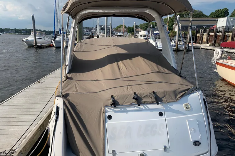 Slide: The Image of 2004 Four Winns 268 Vista boat docked, covered with a protective tarp, in a marina setting. - 10