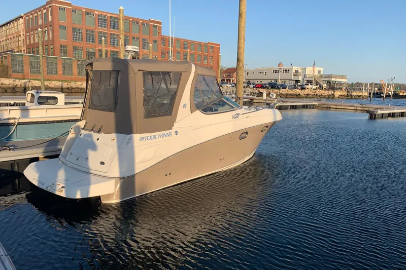 Slide: The Image of 2004 Four Winns 268 Vista boat docked in a marina with industrial buildings in the background. - 12