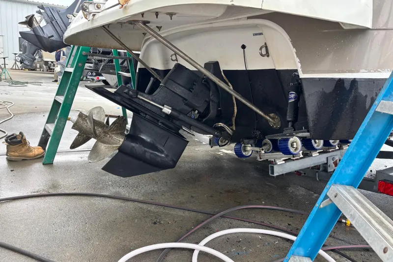 Slide: The Image of 2004 Four Winns 268 Vista boat undergoing maintenance with visible propeller and tools. - 15