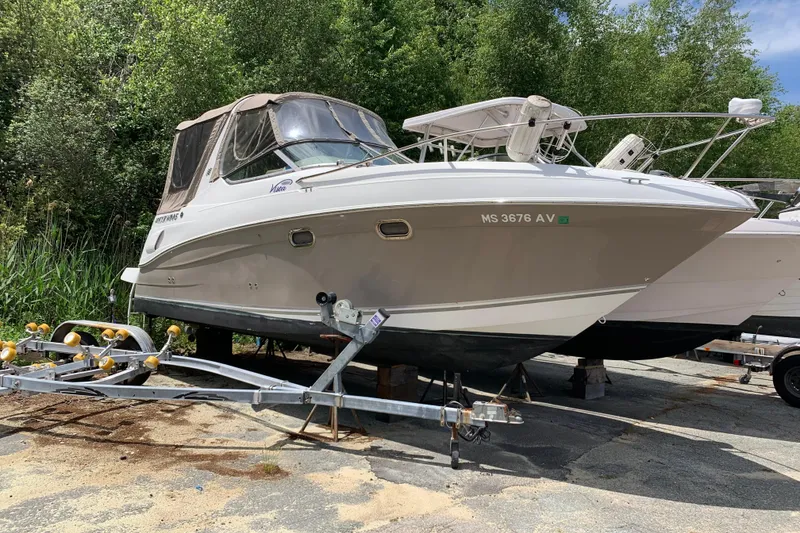 Slide: The Image of 2004 Four Winns 268 Vista boat on trailer, parked outdoors with lush greenery background. - 3