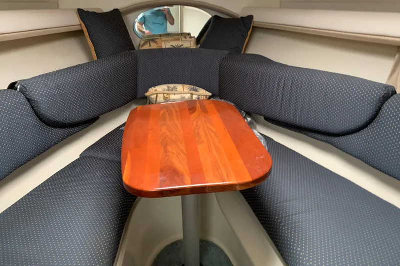 Slide: The Image of Interior of 2004 Four Winns 268 Vista boat with cushioned seating and wooden table. - 4