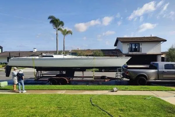 Slide: The Image of 1983 Cape Bay Fast 40 sailboat on trailer, parked in suburban neighborhood. - 10