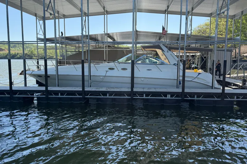 The Image of 2000 Sea Ray 410 Sundancer docked in a covered marina on a sunny day. - 0