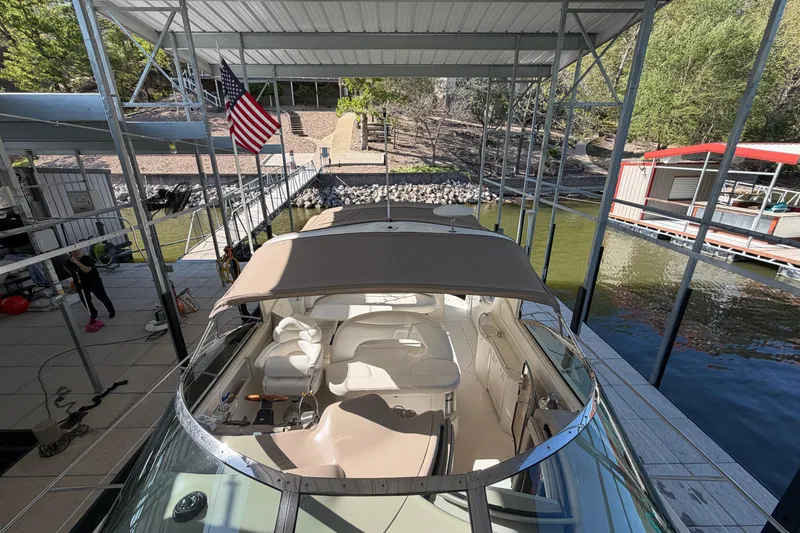 Slide: The Image of 2000 Sea Ray 410 Sundancer docked under a covered marina with American flag. - 10