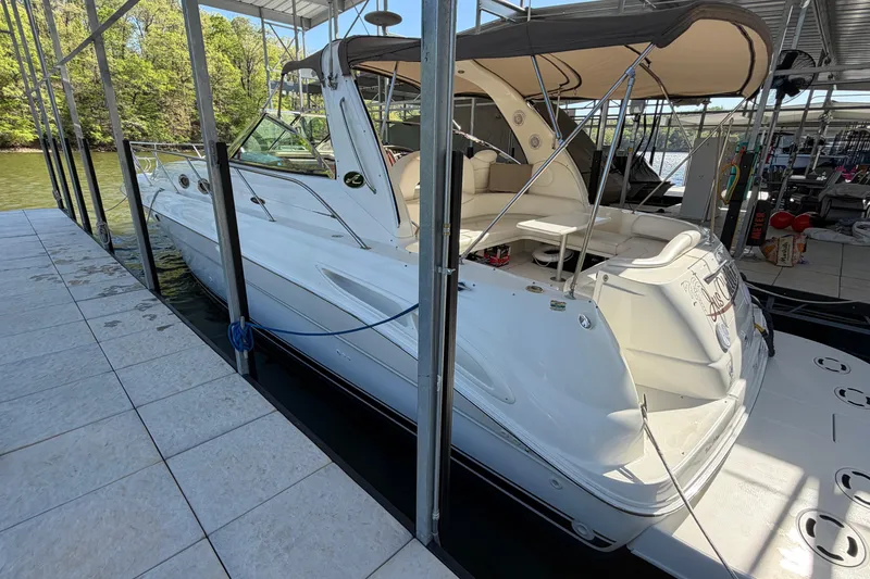 Slide: The Image of 2000 Sea Ray 410 Sundancer docked in a marina, featuring sleek white design and spacious seating. - 11