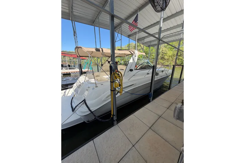 Slide: The Image of 2000 Sea Ray 410 Sundancer docked under a covered marina with American flag. - 12