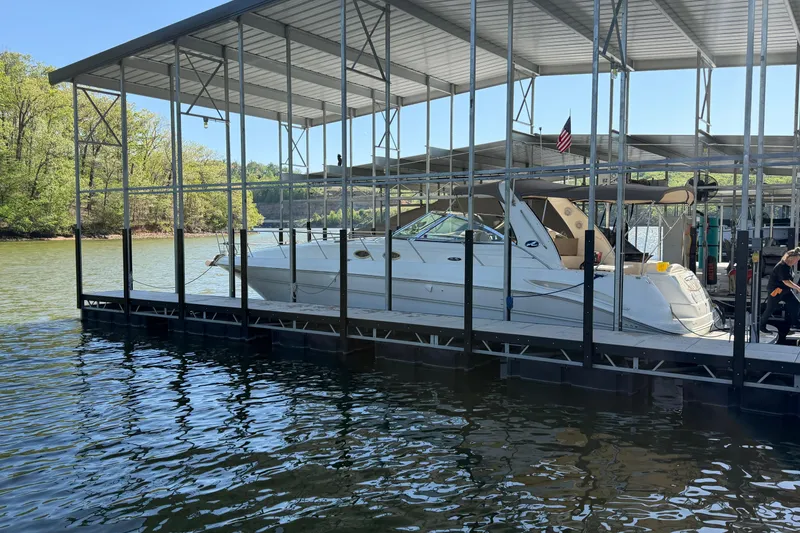 Slide: The Image of 2000 Sea Ray 410 Sundancer docked in a covered marina on a sunny day. - 2