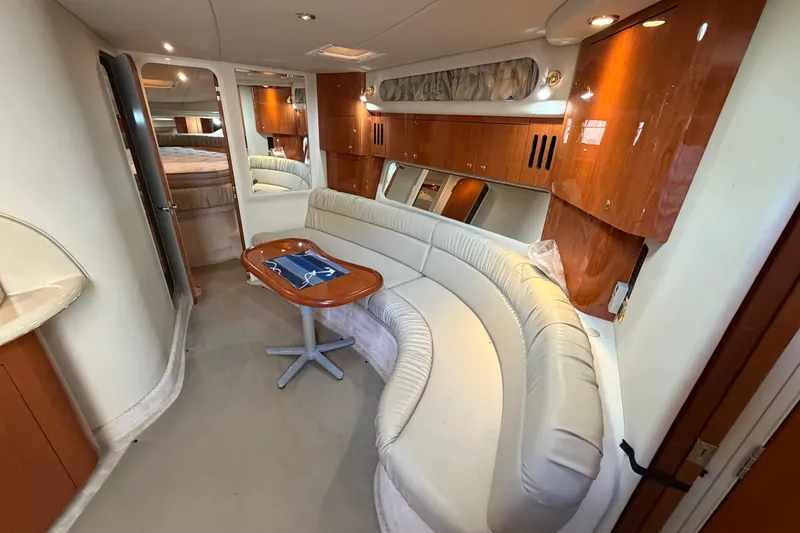 Slide: The Image of Interior of 2000 Sea Ray 410 Sundancer yacht with curved seating and wooden cabinetry. - 31