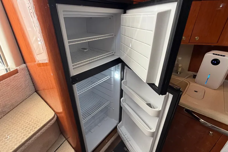 Slide: The Image of Open refrigerator inside 2000 Sea Ray 410 Sundancer yacht kitchen, showcasing storage space. - 33