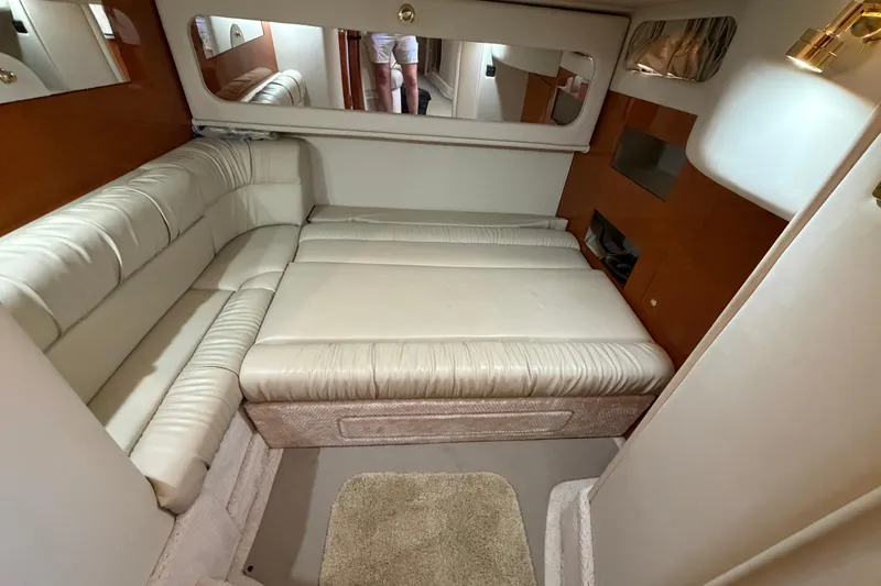 Slide: The Image of Interior of 2000 Sea Ray 410 Sundancer with beige leather seating and cozy cabin layout. - 36