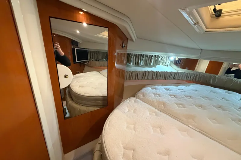 Slide: The Image of Interior cabin of 2000 Sea Ray 410 Sundancer with bed, mirror, and wood paneling. - 43