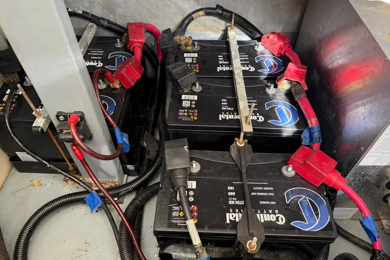 Slide: The Image of Battery compartment of a 2000 Sea Ray 410 Sundancer with connected cables. - 49