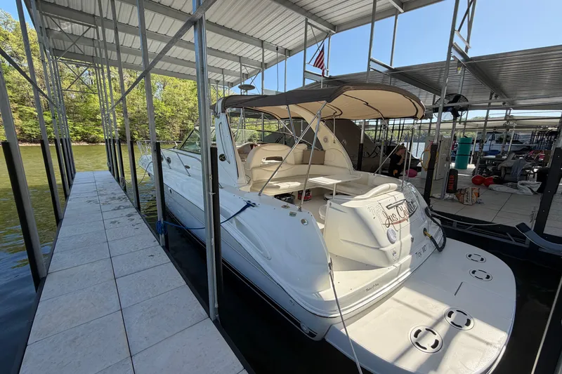 Slide: The Image of 2000 Sea Ray 410 Sundancer docked under a covered marina with scenic background. - 5
