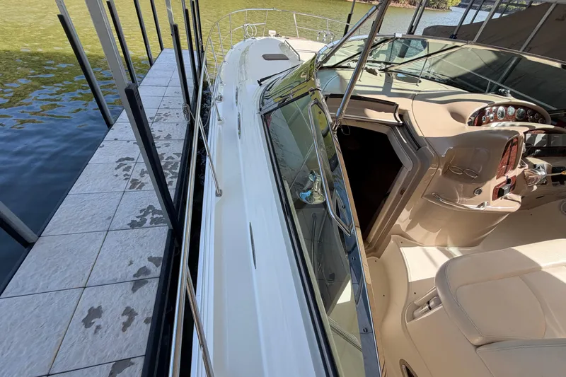 Slide: The Image of 2000 Sea Ray 410 Sundancer yacht docked, showcasing cockpit and sleek design. - 6