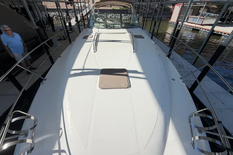 Slide: The Image of 2000 Sea Ray 410 Sundancer yacht docked, showcasing spacious deck and sleek design. - 9