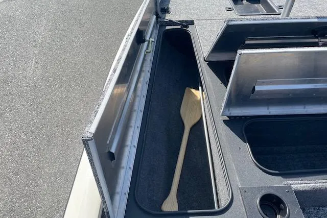 Slide: The Image of 2025 Tracker Pro Team 195 Tournament Edition boat storage compartment with wooden paddle. - 17
