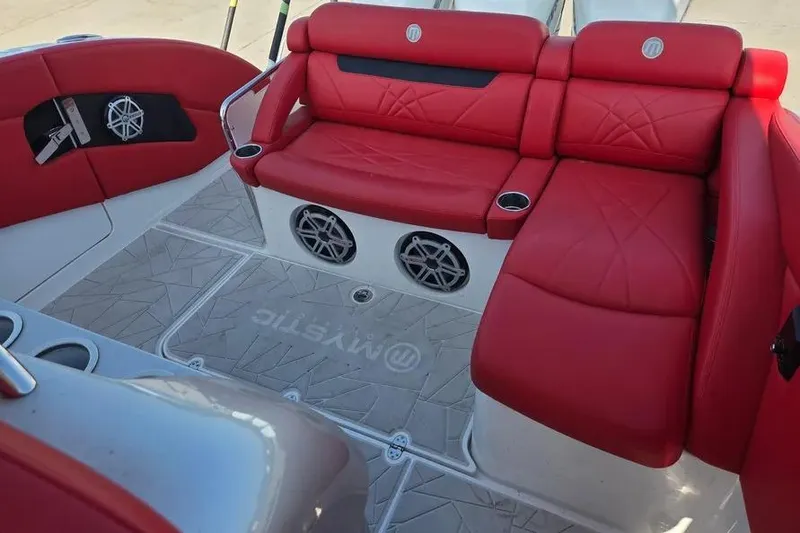 Slide: The Image of Red leather seating on 2019 Mystic Powerboats M4200, featuring cup holders and speaker system. - 11