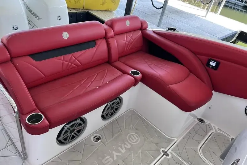 Slide: The Image of Red leather seating on 2019 Mystic Powerboats M4200, featuring cup holders and speakers. - 13
