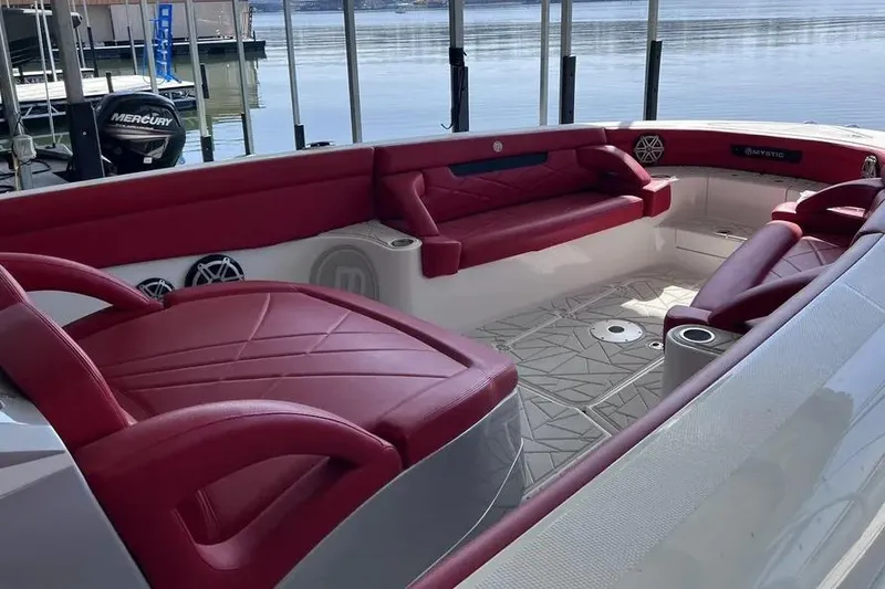 Slide: The Image of 2019 Mystic Powerboats M4200 interior with red seating, docked by calm waters. - 15
